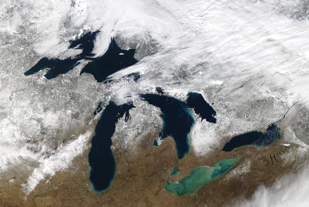 A satellite image of the Great Lakes, showing very little ice cover, some clouds
