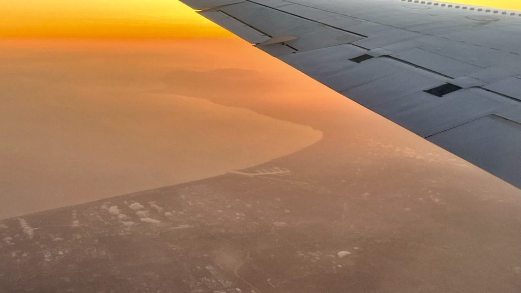 Sunset view from underneath an airplane's wing