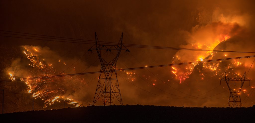 Wildfire blazing behind powerlines